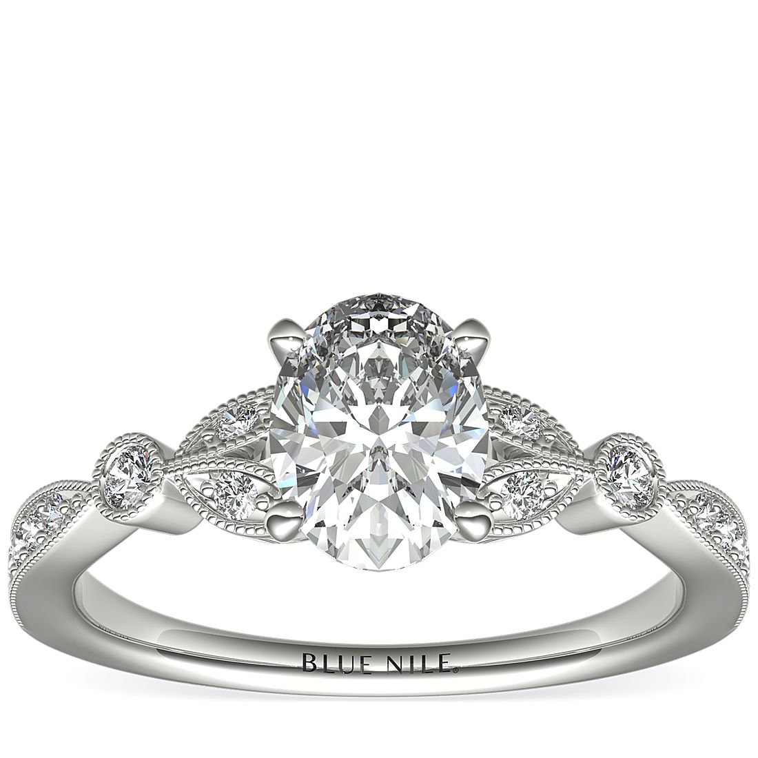 Anillo de compromiso de inspiración retro con un diamante ovalado de 1 quilate rodeado por un borde milgrain.